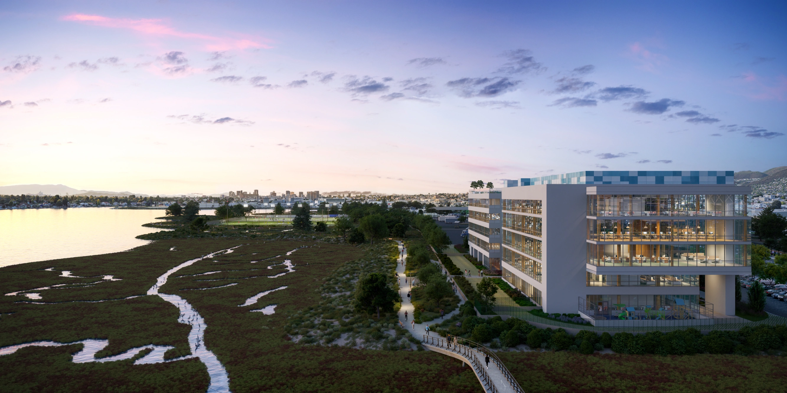 Waterfront marshland at sunset with urban skyline and sports fields